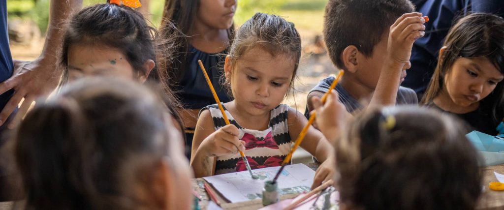 Uma criança pintando um desenho no papel com tinta