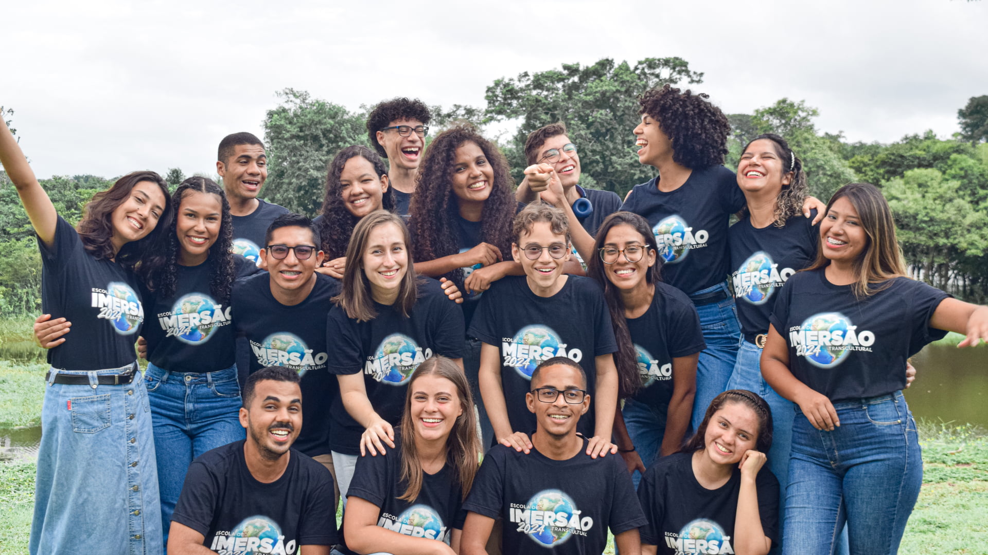 Grupo de jovens felizes e se divertindo, todos com a camiseta da Escola de Imersão Transcultural 2024