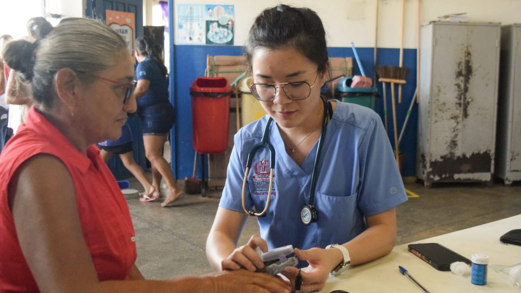 Uma médica aferindo a saturação de uma idosa